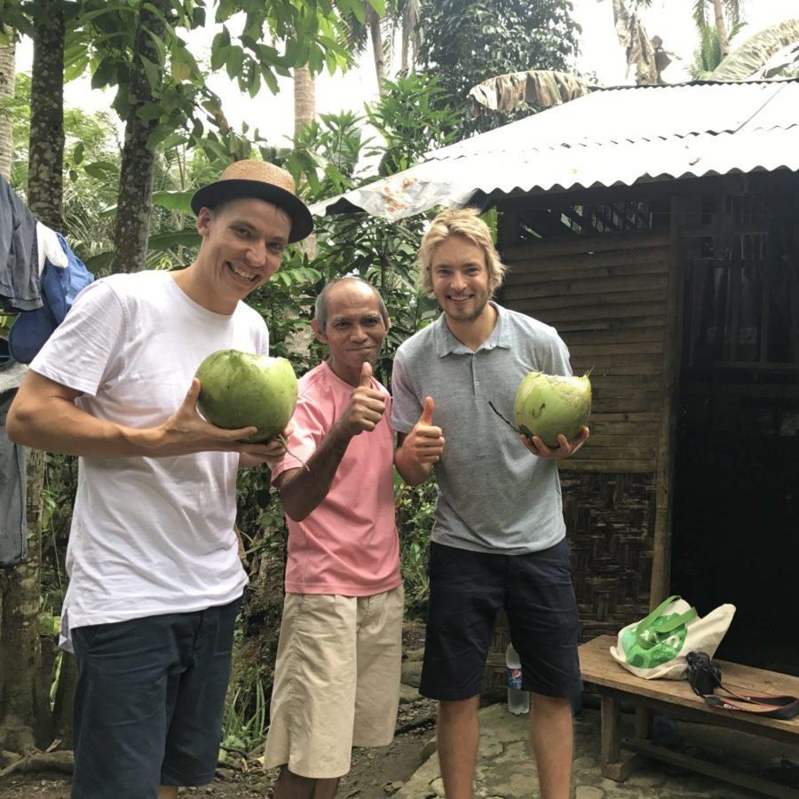 Surfeur saluant, tenant une planche de surf, devant des plantes tropicalesLaird Hamilton  france 