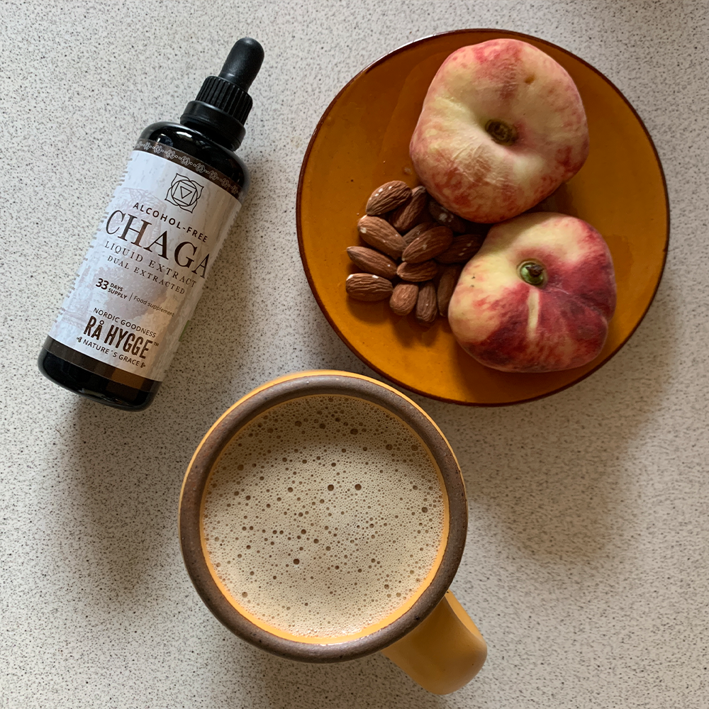 Tasse de café, bouteille de chaga, pommes et amandes sur une table claire. café bio chaga 