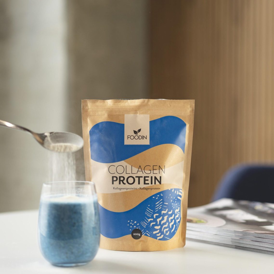 Poudre de protéine collagen dans un sachet doré à côté d'un verre et d'une cuillère. Poudre de protéine collagen dans un sachet doré à côté d'un verre et d'une cuillère.
