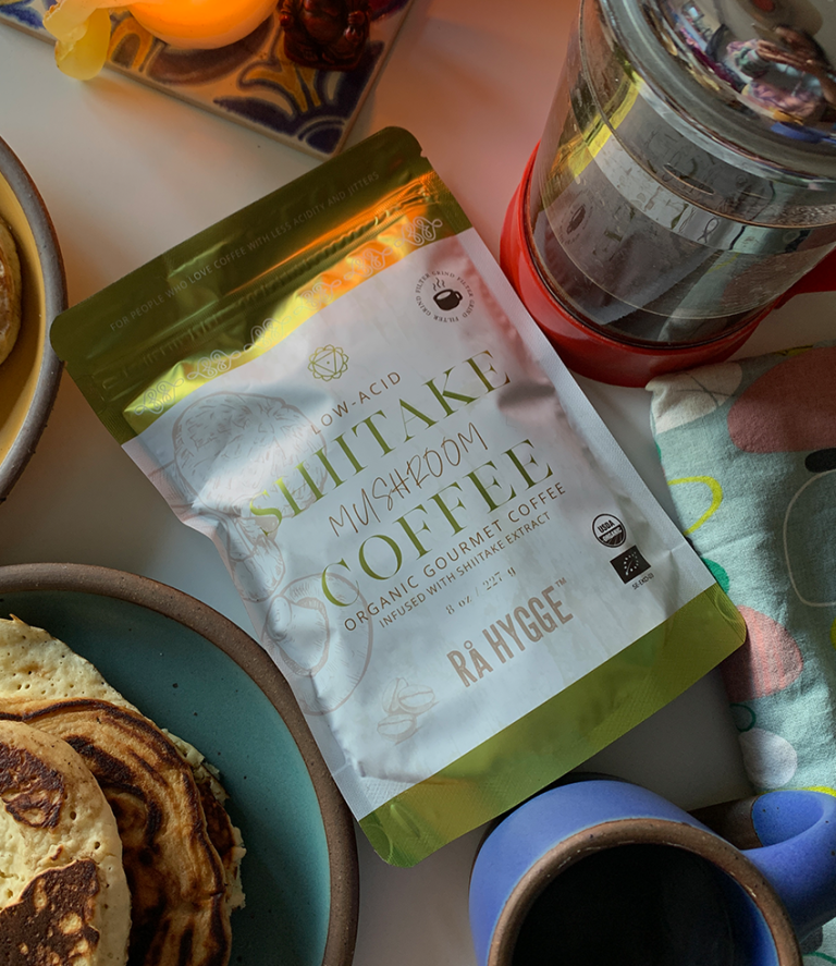 Sachet de café shiitake avec une cafetière et des pancakes en arrière-plan.