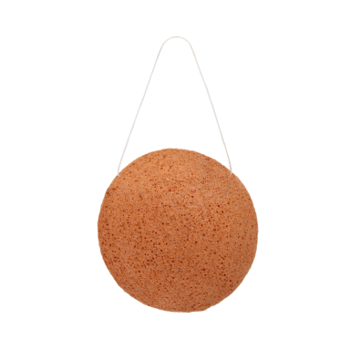Éponge de konjac ronde suspendue par un fil, de couleur brun clair.