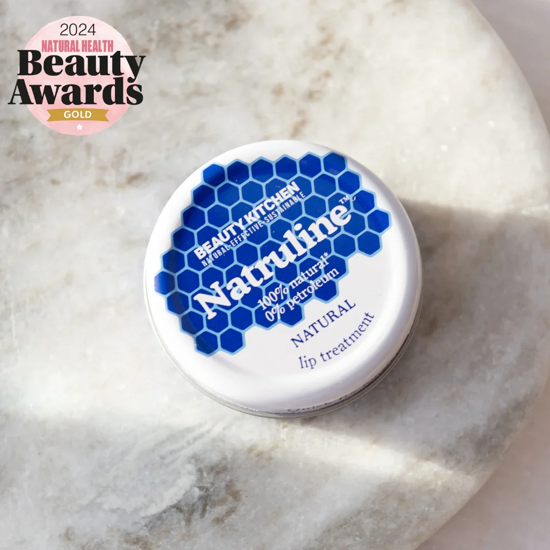 Protégez et réparez vos lèvres naturellement avec Natruline, l'alternative ultime sans plastique à la vaseline. Crème de beauté présentée dans un pot blanc avec motif hexagonal bleuProtégez et réparez vos lèvres naturellement avec Natruline, l'alternat