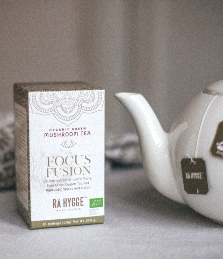 Boîte de thé bio "Focus Fusion" à côté d'une théière blanche.
