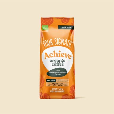 Paquet de café "Achieve" de Four Sigmatic, saveur orange, sur fond beige.
